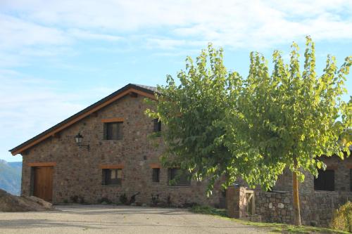 a stone building with a tree in front of it at Les Flors - Hotel Rural & Cabanyes in Gramós