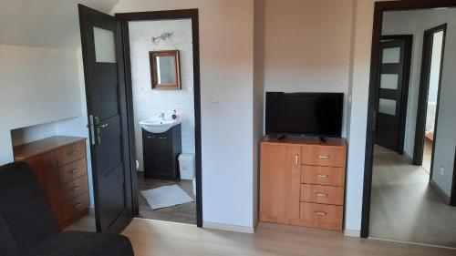 a living room with a television and a bathroom at Dom nad Morzem 79 in Stegna
