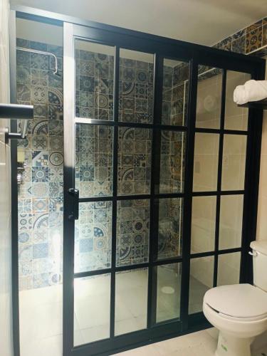 a bathroom with a glass shower with a toilet at Añoranza Hotel Boutique in Ciudad Hidalgo