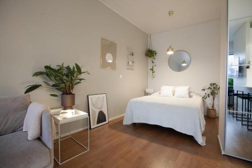 a white bedroom with a bed and a couch at Luxury Nordic Loft with Great Kitchen and Location in Helsinki