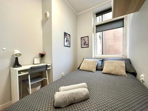 a bedroom with a bed and a desk and a window at MMRent Tiger Room in Gdańsk