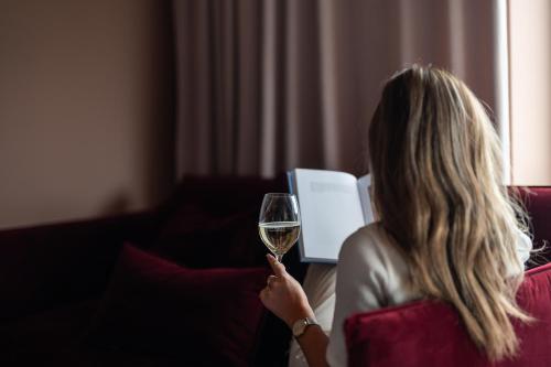 una donna che regge un bicchiere di vino bianco di Quality Hotel Carlia a Uddevalla