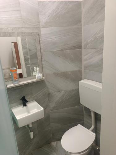 a bathroom with a white toilet and a sink at Speedyrooms Vienna in Vienna