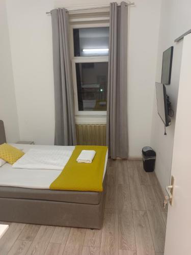 維也納的住宿－Speedyrooms Vienna，一间卧室配有一张带黄色毯子和窗户的床