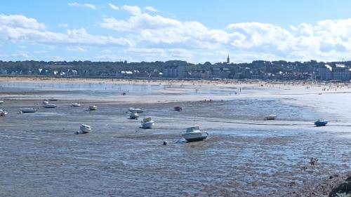 a beach with boats in the water and people on the beach at ANCRE BLEU in Hillion