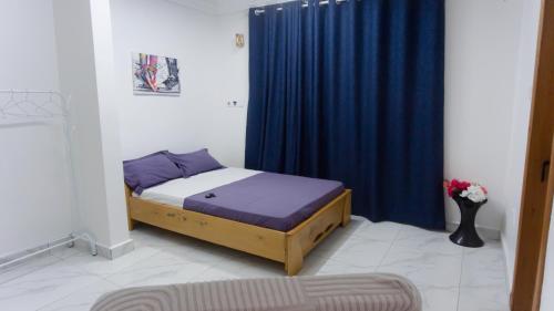 1 dormitorio con 1 cama con cortina azul en MILYREX VILLA, 