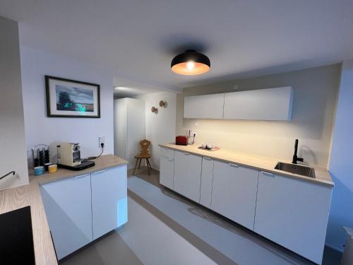 a kitchen with white cabinets and a counter top at B71 - Appartement im Herzen des Schwarzwalds in Schramberg