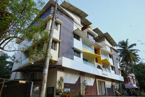 a building with colorful windows and a palm tree at Udupi Kshetra in Udupi