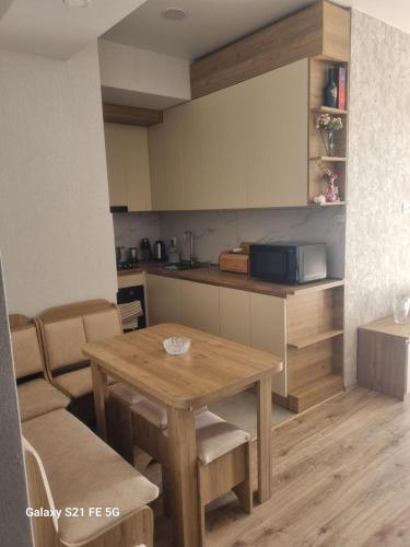 una pequeña cocina con mesa de madera y sillas en Apartment, en Tiflis