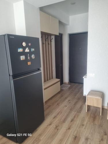 cocina con nevera negra en una habitación en Apartment, en Tiflis