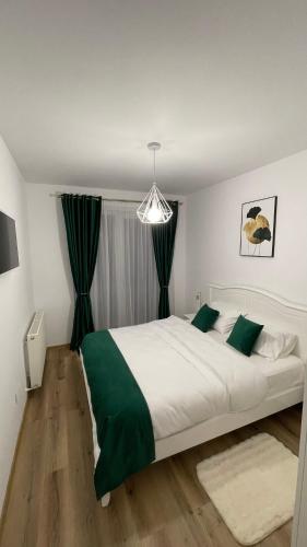 a bedroom with a large white bed with green accents at Alexia Flat in Sibiu