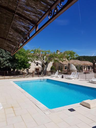 - une piscine entourée d'un parasol et de chaises dans l'établissement Le Moulin de Lavon, à Gargas