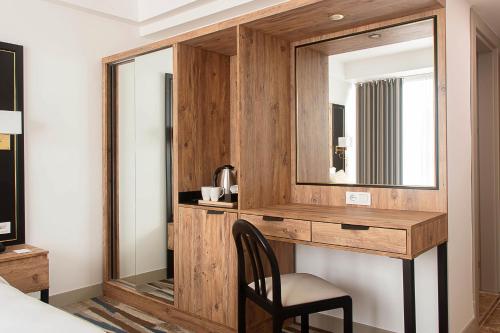 1 dormitorio con escritorio de madera y espejo en Shelter Inn Hotel & Spa en Ankara
