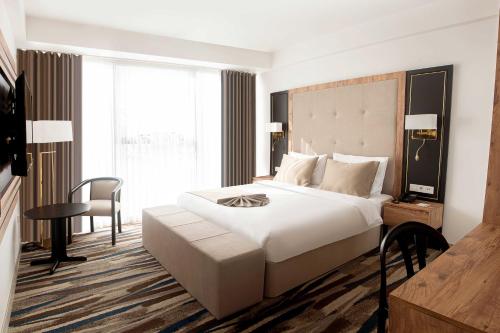 sypialnia z dużym białym łóżkiem i biurkiem w obiekcie Shelter Inn Hotel & Spa w mieście Ankara