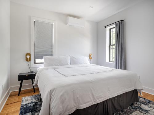 a white bedroom with a large bed and a window at Modern Three Bedroom Brooklyn Condo-Hotel in Brooklyn