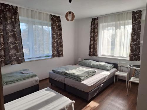 1 dormitorio con 2 camas, mesa y ventanas en Skotnicki Zakątek u Magdy i Tomka, en Samborzec