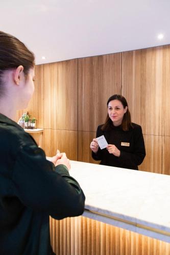 two women standing behind a table in a room at Paxton Paris MLV in Ferrières-en-Brie