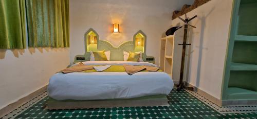 a bedroom with a large bed in a room at Traditional Riad Merzouga Dunes in Merzouga