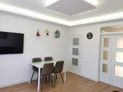 a white dining room with a table and chairs at Bonito Ático in Terrassa