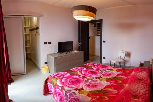 Un dormitorio con una cama con flores rosas. en Suite con vista en Vezzi Portio