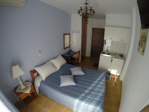 a small bedroom with a bed and a kitchen at Akrotiri Hotel in Neos Marmaras