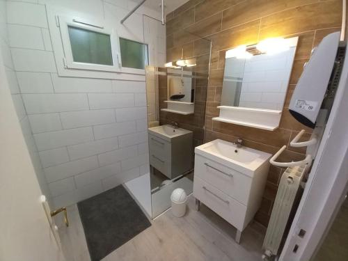 La salle de bains est pourvue d'un lavabo et d'un miroir. dans l'établissement Gîte d'Elvire Maison chaleureuse avec jacuzzi privatif et parc arboré, à Bergerac