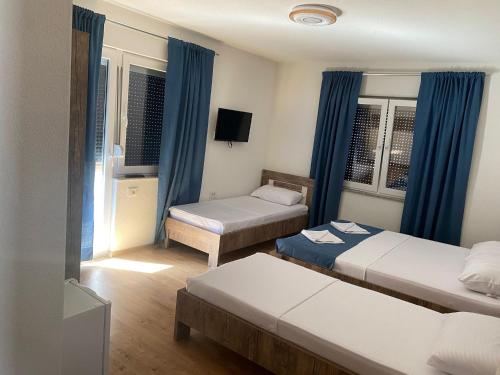 een hotelkamer met 2 bedden en een televisie bij Rooms Ideal in Struga