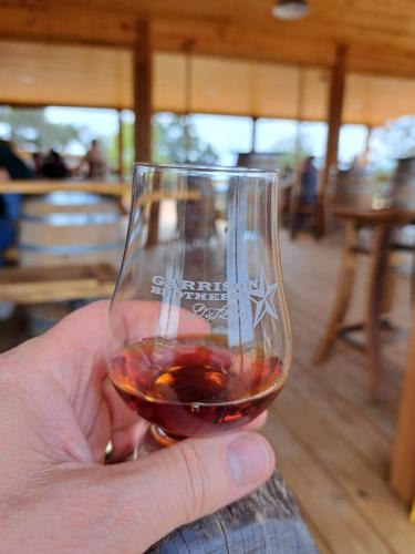 a hand holding a glass of red wine at The Container Retreat @ 290 Wine Trail #9 Get away today! in Hye