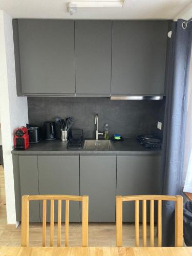 a kitchen with two wooden chairs and a sink at Appartement at the heart of Saas Fee in Saas-Fee