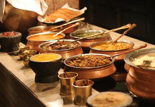 a buffet with many bowls of food on a table at Softouch Ayurveda Village Kerala in Kizhake Chālakudi