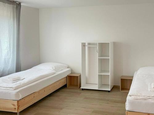 a bedroom with two beds and a white cabinet at T&K Apartments - Wegberg - 3-6 Zimmer Apartments in Wegberg
