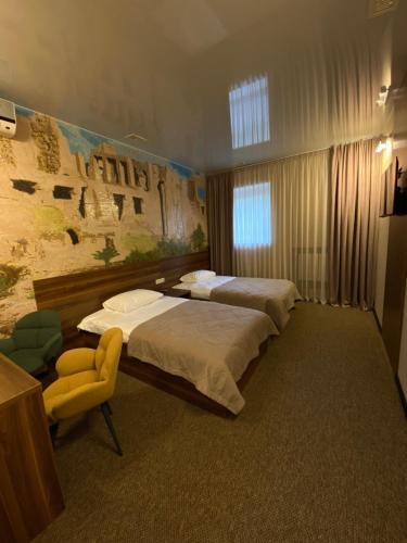 ein Hotelzimmer mit 2 Betten und einem Stuhl in der Unterkunft Status Hotel in Poltawa