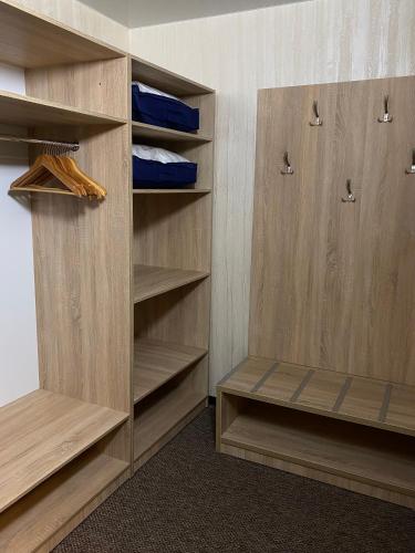 a walk in closet with wooden cabinets and shelves at Status Hotel in Poltava