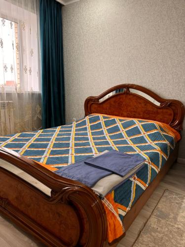 - une chambre avec un lit doté d'un cadre en bois dans l'établissement 1 ком квартира, à Aket