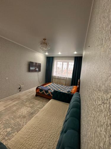 - une chambre avec un lit, un canapé et une fenêtre dans l'établissement 1 ком квартира, à Aket