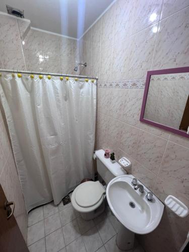 y baño con aseo blanco y lavamanos. en DEPARTAMENTO QUINTA SECCION MENDOZA en Villa Marini