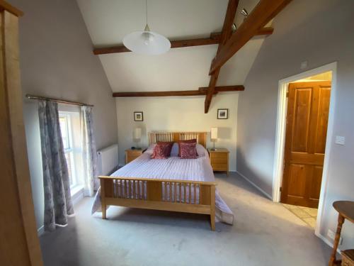 a bedroom with a bed and a large window at Alnwick Holiday House - Charming, Historic, Central Alnwick with Courtyard in Alnwick