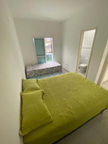 1 dormitorio con cama verde y espejo en Casa de Praia - Distância de 100 metros en Praia Grande