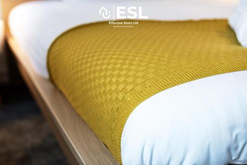 a close up of a bed with a yellow mattress at 3 bedroom House - Next to Wrexham FC Racecourse Stadium in Wrexham
