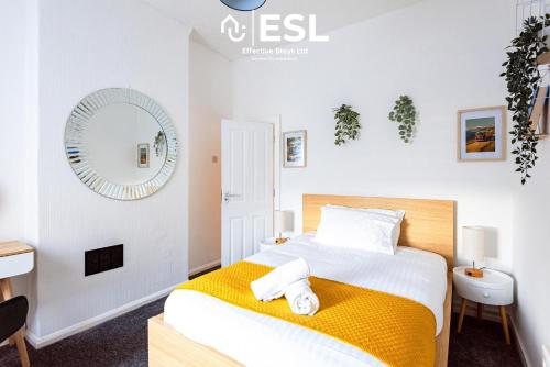 a bedroom with a bed and a mirror at 3 bedroom House - Next to Wrexham FC Racecourse Stadium in Wrexham