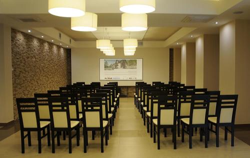 a room with a bunch of chairs and a screen at Hotel Klaudia in Juszczyn
