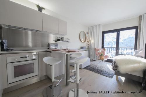 une cuisine avec une table et des chaises dans une pièce dans l'établissement NID DOUILLET DE FLAINE, à Flaine