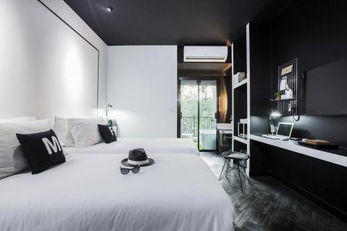 a bedroom with a white bed with a hat on it at Blu Monkey Hub and Hotel Phuket Town- Free All Day Coworking space in Phuket Town