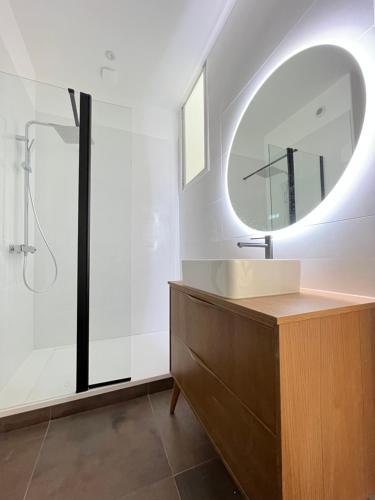 une salle de bain avec un lavabo et un miroir dans l'établissement Maison de vacances, à Châtelaillon-Plage