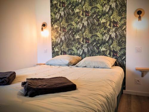 1 cama con 2 almohadas y pared en Urban Jungle 42, en Saint-Étienne