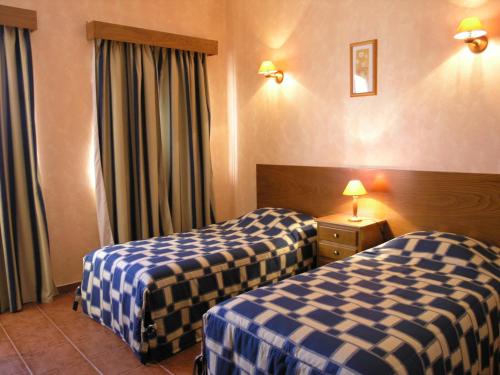 Quinta Marvão في ريبامار: غرفة فندقية بسريرين ذات شراشف زرقاء وبيضاء