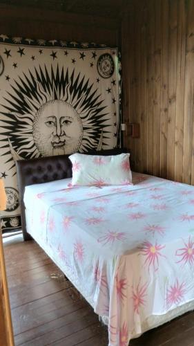a bedroom with a bed with a sun painted on the wall at Casas Paz e Amor Praia do Rosa Sunset e Sunrise in Imbituba