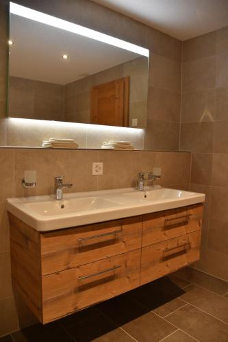 a bathroom with a sink and a mirror at FERIENWOHNUNGEN Chalet Hohturnen in Grindelwald