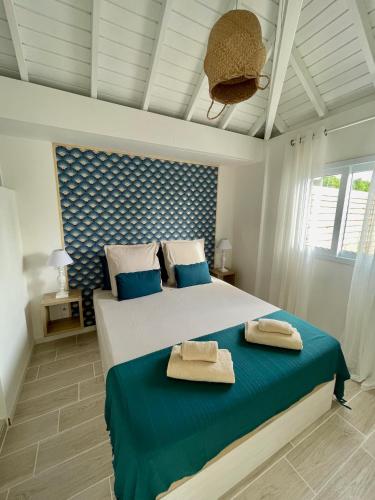 a bedroom with a bed with two towels on it at La Papaye d’Or in Saint-François