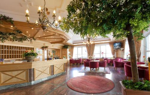 ein Restaurant mit einer Bar mit roten Stühlen und einem Baum in der Unterkunft Gasthof Pitztaler Hof in Wenns